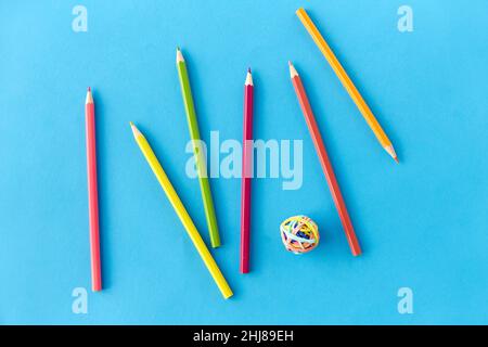 crayons de coloriage et bandes en caoutchouc sur fond bleu Banque D'Images