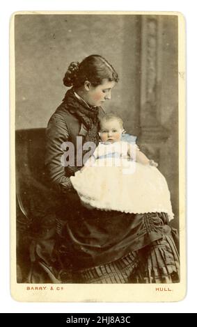 Original victorien teinté carte de visite (CDV) de belle mère regardant tendinement son bébé qui est habillé dans une robe blanche, peut-être une robe de baptême.La femme a une coiffure de chignon, et la robe qui a une agitation.Du studio de Barry & Co. Hull, Yorkshire, Angleterre, Royaume-Uni vers 1875. Banque D'Images