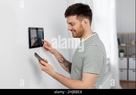 homme souriant utilisant une tablette dans une maison intelligente Banque D'Images