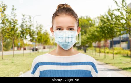 adolescente dans un masque médical dans la rue de la ville Banque D'Images