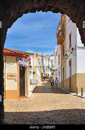 Scène de rue à travers la porte de ville, Silves, région de l'Algarve, Portugal Banque D'Images