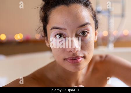 Portrait en gros plan de la jeune femme biraciale confiante dans la baignoire au spa. Non modifié, spa, soins du corps, mode de vie, sensualité,vitiligo et bien-être. Banque D'Images