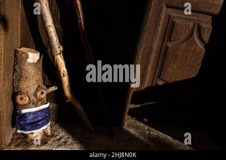 gnome de bois ou log avec masque anti-covid, penchée à l'extérieur d'une maison rurale dans les bois. Banque D'Images