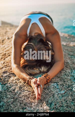 Toujours rester humble et gentil.Photo d'une jeune femme pratiquant le yoga sur la plage. Banque D'Images