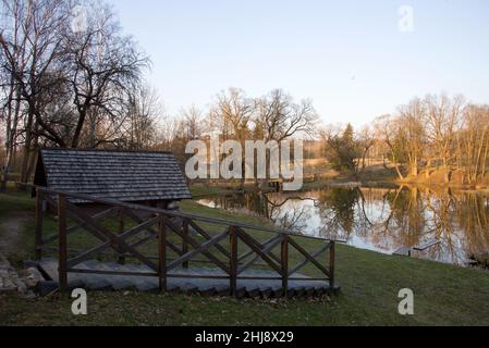 Ancienne maison en bois au bord de la forêt près du lac au printemps.Village de pêcheurs.Extérieur traditionnel de style soviétique ou russe Banque D'Images