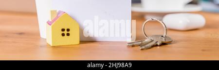 Porte-clés et porte-clés en forme de maison sur fond bleu. Banque D'Images