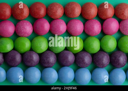 Boules de bonbons de différentes couleurs.Ligne rose, violet, bleu, vert et rouge.Papier peint unique, inhabituel.Sucre, bonbons, joie de vie, enfance, perles,amusant Banque D'Images