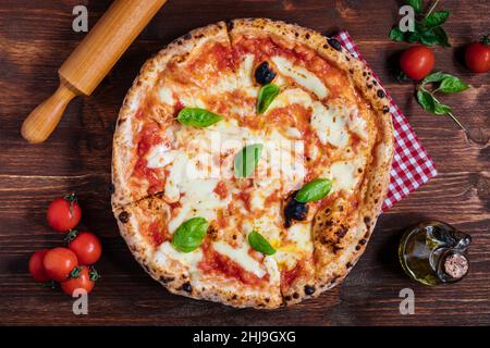 Pizza Napoletana, pizza italienne traditionnelle et authentique cuite au four à bois.Pizza Margherita au fromage mozzarella, sauce tomate, huile d'olive. Banque D'Images