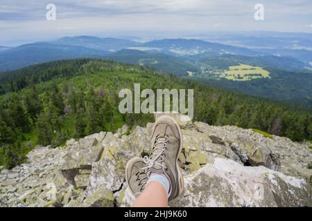 Jambes de la femme voyageur assis sur de hauts rochers.liberté Wanderlust Voyage concept.Trekking bottes contre beau paysage.merveilleux à couper le souffle Banque D'Images