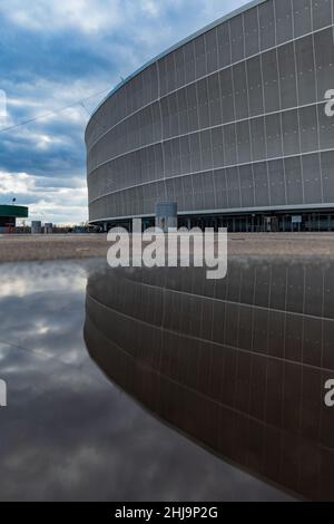 Wroclaw, Pologne - Mars 2021: Le stade de Wroclaw bâtiment à la journée ensoleillée nuageux se reflète dans la flaque Banque D'Images