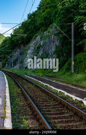 Photographie des voies ferrées de la gare d'Herculane, Roumanie, montrant les fils et le feu rouge Banque D'Images