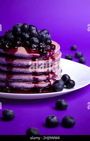 Crêpes au lait de beurre violet maison, garnies de bleuets et de sirop Banque D'Images