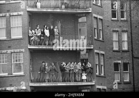 Course de bateaux Oxford Verses Cambridge, sur la Tamise, Londres, 23rd mars 1963.Les spectateurs apprécient la journée depuis une résidence dans la région de Barnes.La course de bateaux de 109th a eu lieu le 23 mars 1963.Organisé chaque année, l'événement est une course d'aviron côte à côte entre les équipes des universités d'Oxford et de Cambridge le long de la Tamise.La course, à l'aide de Gerald Ellison, l'évêque de Chester, a été remportée par Oxford avec une marge de cinq longueurs.Photo prise le 23rd mars 1963 Banque D'Images