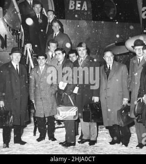 L'équipe de football de Manchester United vole de Manchester Runway à Dublin pour un match contre Coventry, dans la neige épaisse.le match a été organisé parce que le Derby local prévu de Manchester United vers Manchester City avait été appelé la veille.Matt Busby est photographié à l'extrême gauche, et l'assistant Jimmy Murphy est troisième à droite.(écharpe/fourre-tout, pantalon plus foncé et sourire à sa gauche) Bobby Charlton est à 3rd du haut debout sur les marches de l'avion, comme l'équipe pose pour les caméras avant de monter dans l'avion.Photo prise le 1st février 1963 Banque D'Images