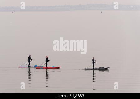 Paddle-board sur l'estuaire de la Tamise tôt sur une mer calme et plate de retour en direction de Chalkwell après avoir passé Southend Pier.Brumeux, calme mort Banque D'Images