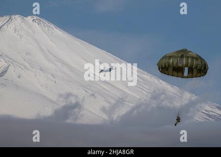 Un parachutiste de la Force terrestre d'autodéfense du Japon affecté à la Brigade aéroportée 1st descend d'un Super Hercules C-130J de la Force aérienne des États-Unis affecté au Escadron de transport aérien 36th au-dessus du Centre d'entraînement d'armes combinées Camp Fuji, au Japon, pendant Airborne 22, le 25 janvier 2022.Le partenariat en cours entre les forces américaines et japonaises continue de démontrer l’engagement des deux pays à maintenir la stabilité et la sécurité dans toute la région Indo-Pacifique.(É.-U.Photo de la Force aérienne par le premier Airman Brieana E. Bolfing) Banque D'Images