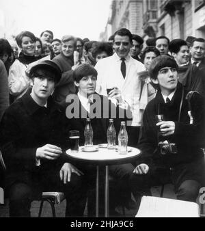 Trois Beatles - Jean, Paul et George Profitez d'un verre de coca cola dans un café de rue à Paris France 15th janvier 1964.George porte sa caméra Pentax.Les Beatles se sont rendus au Théâtre Olympia de Paris, poursuivant leur résidence de 18 dates qui a commencé le 16 janvier 1964 et s'est terminée le 4 février.C'est à Paris qu'ils ont appris qu'ils étaient numéro un dans les charts américains, ce qui a incité une visite à New York la semaine suivante, où ils ont conquis l'Amérique apparaissant pour la première fois sur le Ed Sullivan Show.Photo prise le 15th janvier 1964 Banque D'Images