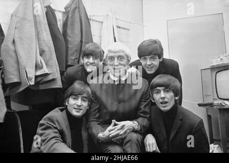 Disc Jockey Jimmy Saville en photo avec le groupe pop de Liverpool The Beatles à Finsbury Park Astoria à Londres. The Beatles et Saville ont figuré ensemble sur le tout premier programme Top of the POPS le jour de l'an 1964.Les Beatles sont de gauche à droite, rangée arrière : le batteur Ringo Starr et le guitariste de basse Paul McCartney.Avant : John Lennon et George Harrison.11th janvier 1964. Banque D'Images