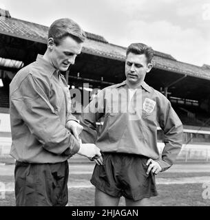 Séance d'entraînement de l'équipe de football d'Angleterre au pont Stamford avant leur match international contre le Brésil à Wembley.George Eastham montre sa main blessée au joueur de Liverpool Gordon Milne, gagnant sa première casquette anglaise dans le match.6th mai 1963. Banque D'Images