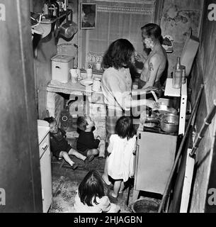 M. Sutton Pownall, gravedigger, vit au Tribunal numéro deux, rue Dickenson, Oldham, avec sa femme Joyce et leurs cinq enfants dans une maison de 150 ans.La famille partage une chambre, une cuisine et un salon.Ils partagent une clé pour les toilettes communes, près de l'endroit où les poubelles sont empilées.Ses enfants sont Susan, 6, Steve, 5, Sandra,4, Mark, 3 et Baby Gary, âgés de 8 mois.1st juin 1962. Banque D'Images