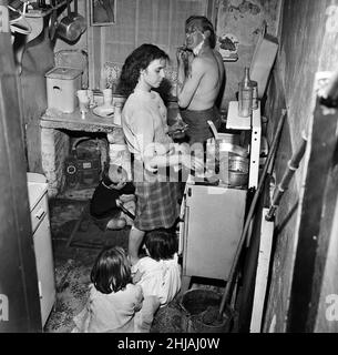 M. Sutton Pownall, gravedigger, vit au Tribunal numéro deux, rue Dickenson, Oldham, avec sa femme Joyce et leurs cinq enfants dans une maison de 150 ans.La famille partage une chambre, une cuisine et un salon.Ils partagent une clé pour les toilettes communes, près de l'endroit où les poubelles sont empilées.Ses enfants sont Susan, 6, Steve, 5, Sandra,4, Mark, 3 et Baby Gary, âgés de 8 mois.1st juin 1962. Banque D'Images