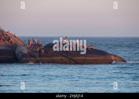 Coucher de soleil vu de Pedra do Arpoador à Rio de Janeiro, Brésil - 17 janvier 2022: Personnes attendant le coucher de soleil à Pedra do Arpoador à Rio de Janeiro. Banque D'Images