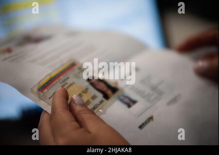 Bogota, Colombie.27th janvier 2022.Un agent de migration vérifie une pièce d'identité vénézuélienne avant de remettre le permis de séjour temporaire pour les migrants vénézuélien le 27 janvier 2022.Colombie migration organise des événements de masse pour accorder plus de 70,000 000 ID d'autorisation temporaire aux migrants vénézuéliens en l'espace de 7 jours.Crédit : long Visual Press/Alamy Live News Banque D'Images