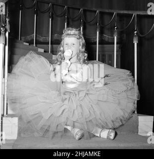 Une jeune fille dans sa robe de balle de style crinoline prend une pause de glace pendant le concours Junior Old Time Dancing au Palais Hammersmith.4th juin 1963. Banque D'Images