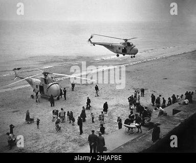 Un deuxième hélicoptère à tourbillon de Westland apporte de l'aide à l'hélicoptère de sauvetage aérien en mer de la RAF de l'escadron de vol D 202 de la RAF Leconfield qui a atterri sur la plage sud à Bridlington avec des problèmes mécaniques.25th septembre 1962 Banque D'Images