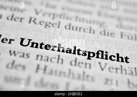 Gros plan sur le mot allemand en surbrillance « Unterhaltsflicht » dans un journal. Traduction : maintenance Banque D'Images