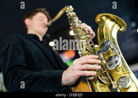 Musicien de jazz masculin jouant un saxophone dans un restaurant Banque D'Images