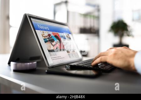 Regarder des nouvelles à l'écran. Lecture du site Web du journal sur ordinateur portable Banque D'Images