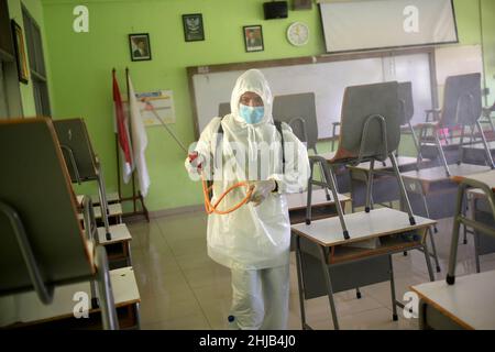 Jakarta, Indonésie.28th janvier 2022.Un membre de la Société indonésienne de la Croix-Rouge procède à la désinfection dans un bâtiment scolaire de Jakarta, en Indonésie, le 28 janvier 2022.L'Indonésie a confirmé jeudi 8 077 nouveaux cas de COVID-19, soit la plus forte augmentation d'un jour depuis le 2 septembre 2021, dans le contexte de la propagation de la variante Omicron dans le pays.Credit: Zulkarnain/Xinhua/Alamy Live News Banque D'Images