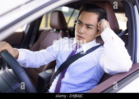 Un homme d'affaires lassé et fatigué conduisant la voiture et attendant dans un embouteillage Banque D'Images