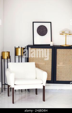 Commode ou commode en bois noir avec affiche carte encadrée d'étoiles, lampe et bougie contre le mur lumineux dans un intérieur contemporain minimaliste.Intérieur des Banque D'Images