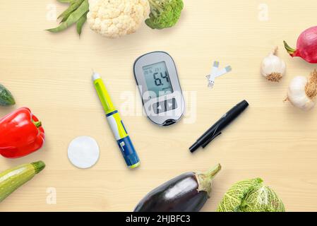 Composition concept de diabète avec glucomètre et insuline entouré d'aliments sains, légumes.Vue de dessus, plan d'appartement Banque D'Images