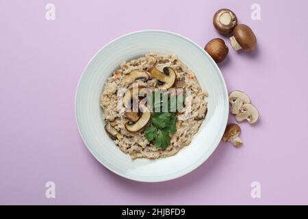 Assiette de risotto aux champignons et aux ingrédients sur fond violet Banque D'Images