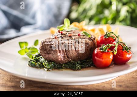 Steak bien fait servi avec des légumes sur une assiette prête à être mangé. Banque D'Images