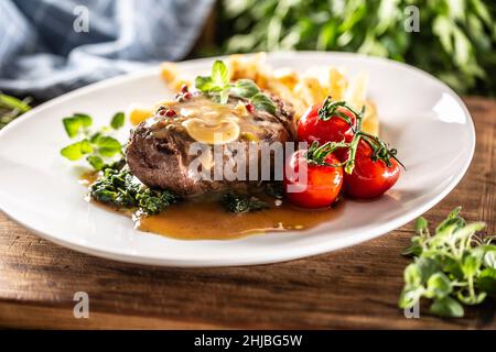 Steak juteux à la sauce servi avec des légumes sur une assiette bien présentée. Banque D'Images