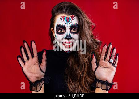 jeune femme mexicaine en costume de Calavera Catrina sur fond rouge de studio Banque D'Images