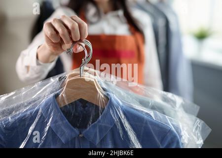 Un employé professionnel garde des vêtements propres sur les cintres Banque D'Images