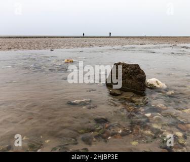 Deux silhouettes de personnes marchant sur la plage en janvier, Worthing, West Sussex, Royaume-Uni Banque D'Images