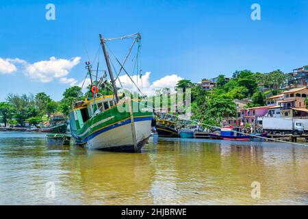 Grand bateau de pêche au bord de la côte où les maisons peuvent être vues.La communauté de pêcheurs de Jurujuba fait partie de la côte de la baie de Guanabara dans la ville de Niteroi, RI Banque D'Images