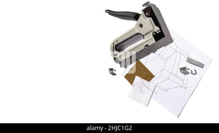 Pistolet à agrafes argenté pour meubles et dessin du fauteuil.Outil industriel manuel.Vue de dessus avec espace de copie pour le texte Banque D'Images