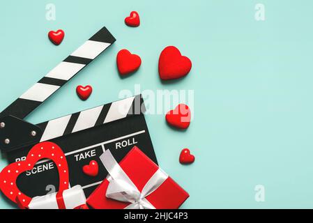 Bonne Saint Valentin.Clapperboard à coeurs rouges, boîte de cadeaux de la Saint-Valentin et espace de copie sur fond bleu.Concept de film romantique Banque D'Images