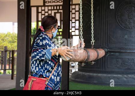 Voyageurs femmes thaïlandaises personnes Voyage visite au temple de Wat Tham Panyaram Bangmuang et frapper grand gong de cloche pour le respect priant la divinité à Sam Phran ci Banque D'Images