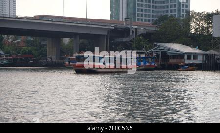 Pont de Sathon alias Saphan Taksin Bridge traversez la rivière Chao Phraya à Bangkok en Thaïlande avec un ferry Banque D'Images