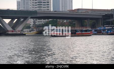 Pont de Sathon alias Saphan Taksin Bridge traversez la rivière Chao Phraya à Bangkok en Thaïlande avec un ferry Banque D'Images