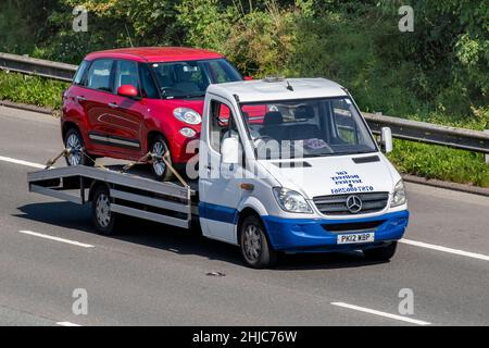 2012 Mercedes Benz 2143cc Sprinter blanc services de livraison de voitures à faible chargeuse transportant des SUV de croix Fiat 500 rouges sur l'autoroute M61, Royaume-Uni Banque D'Images