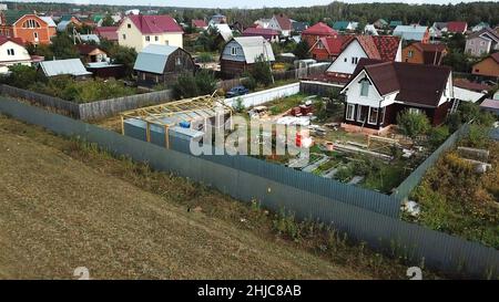 Vue aérienne du village de chalets près du champ vide pour la construction future à la fin de l'été contre ciel bleu nuageux.Magnifique paysage de campagne Banque D'Images